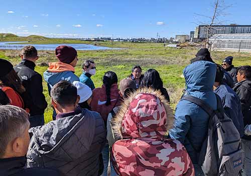 Professor Emily Moran shows visiting students the campus's greenhouses and poplar grove.