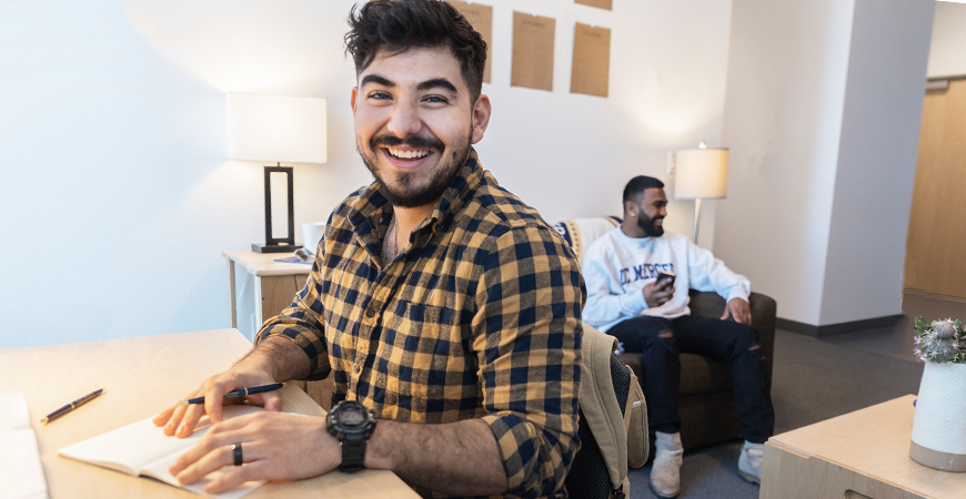 Two make graduate students sitting in residence hall